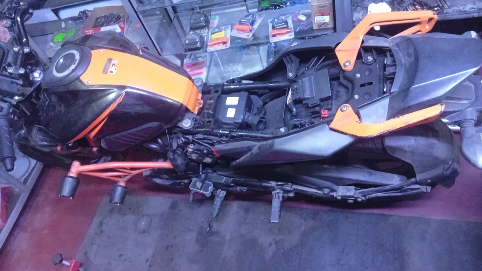 Moto sin carenados en el area de trabajo, con el chasis y el cableado a la vista