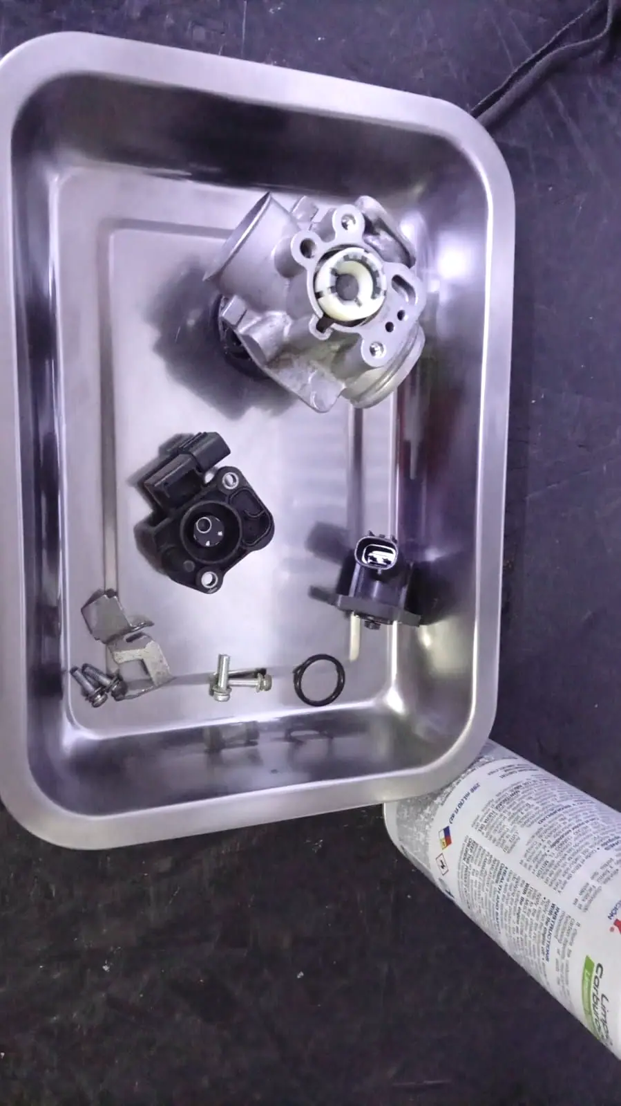 Cuerpo de inyección desmontado junto a su sensor y el inyector